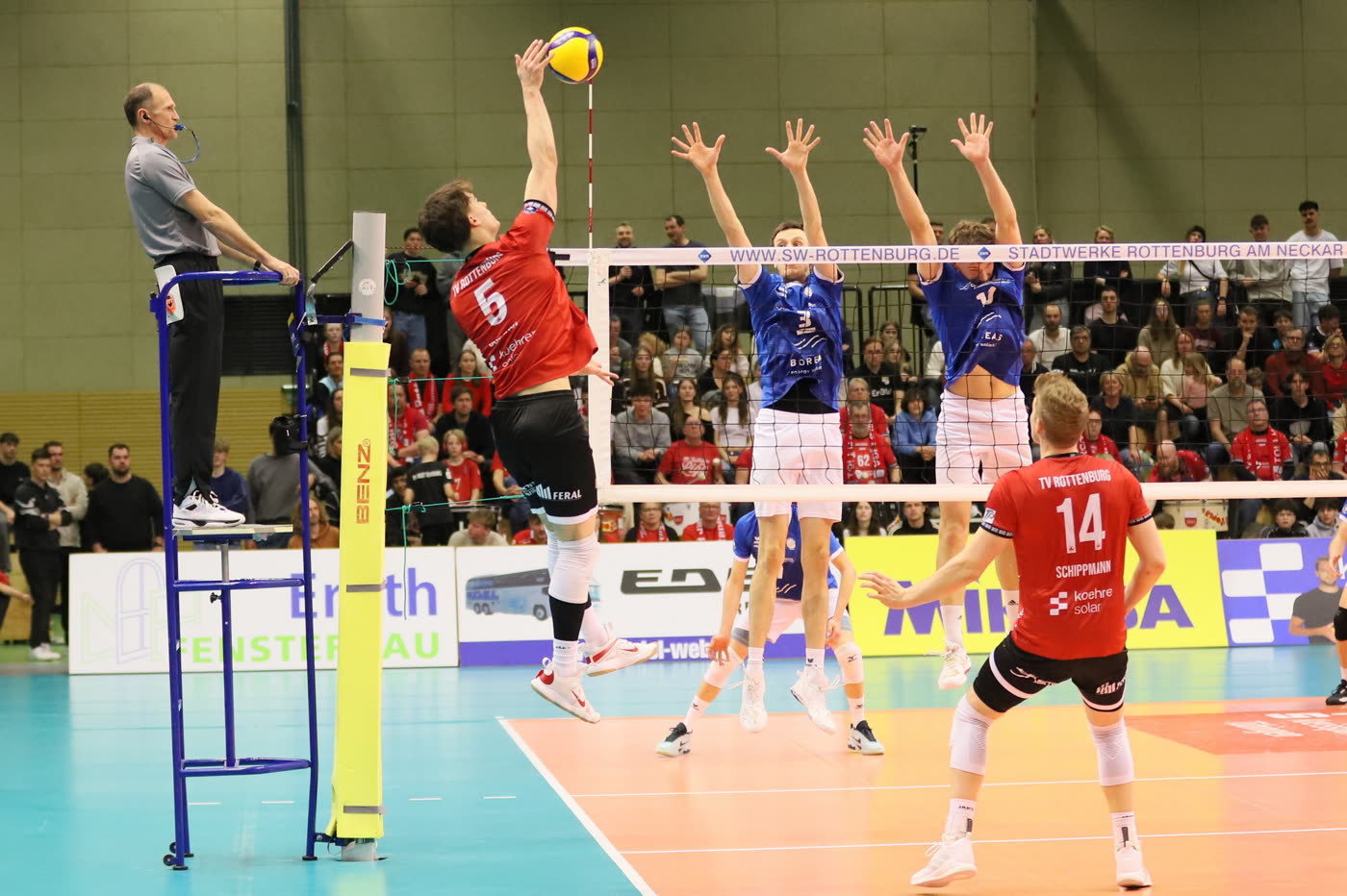 Zwei Spieler des TV Rottenburg blocken am Netz einen Angriff ab.